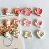 A set of 12 pink and white kawaii flower decorative fridge magnets arranged on a white background.