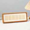 A solid wood photo frame display stand with six rectangular slots for displaying photos.