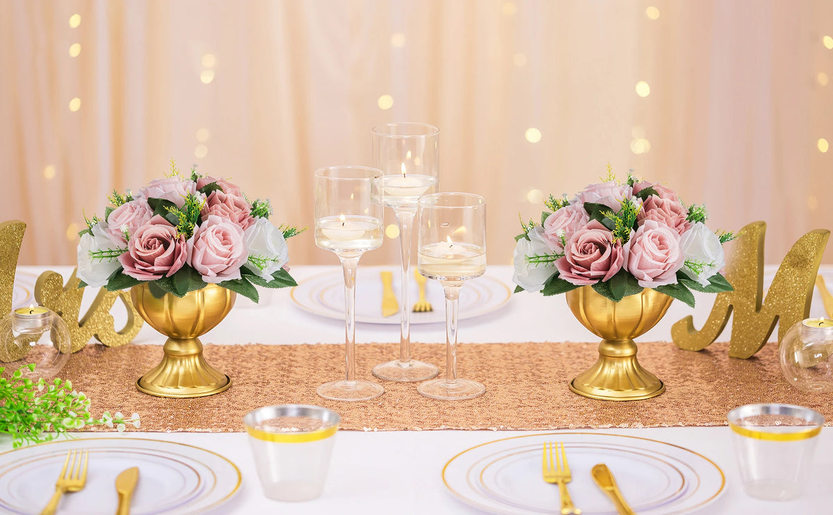 A table setting featuring rose ball centerpieces with silk artificial flowers and gold accents.
