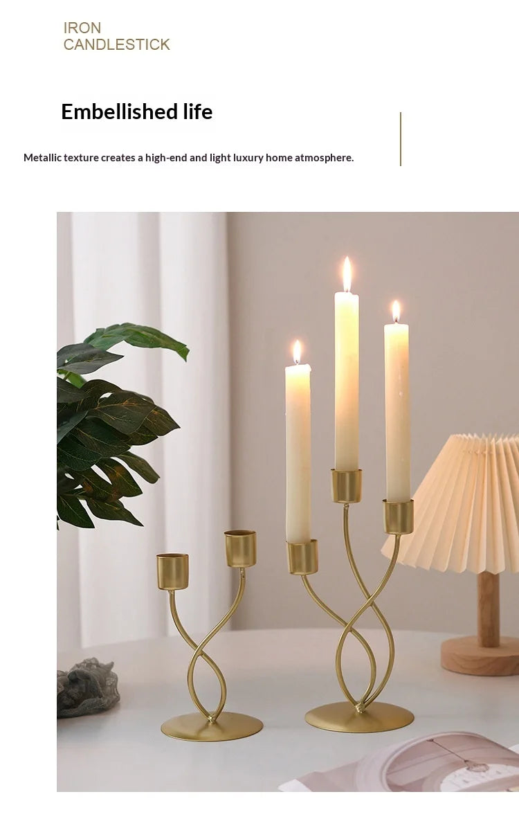 A set of tall, slender iron candlesticks with white wax candles displayed on a light-colored table.