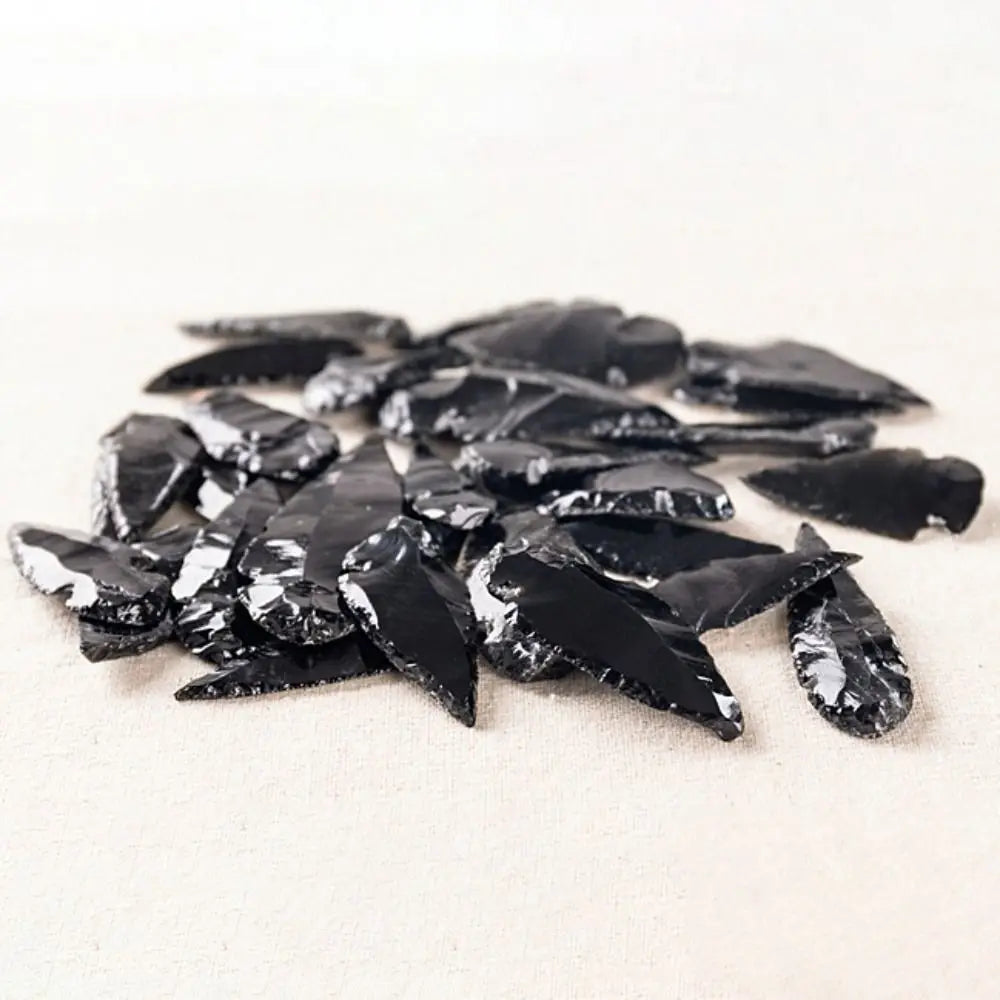 A pile of sharp, black obsidian shards used as a natural crystal for healing charms.