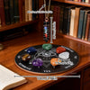 Un collier avec un pendentif de pierre noire, suspendu au-dessus d'un jeu de divination avec diverses cristaux colorés et une