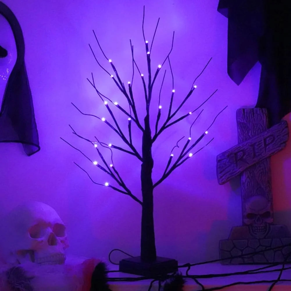 A dark silhouette of a birch tree with glowing LED lights against a purple background.