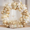 A large balloon garland featuring beige and gold balloons arranged in an archway.