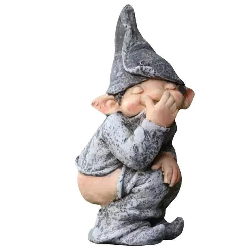 A small statue of a gnome with a pointed hat and a surprised expression, painted in gray and white.