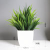 A vibrant green artificial bonsai plant with eucalyptus accents potted in a white square ceramic pot.