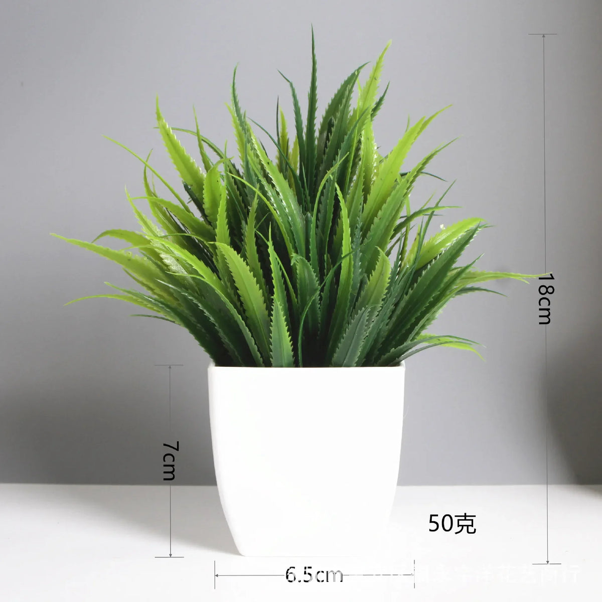 A vibrant green artificial bonsai plant with eucalyptus accents potted in a white square ceramic pot.