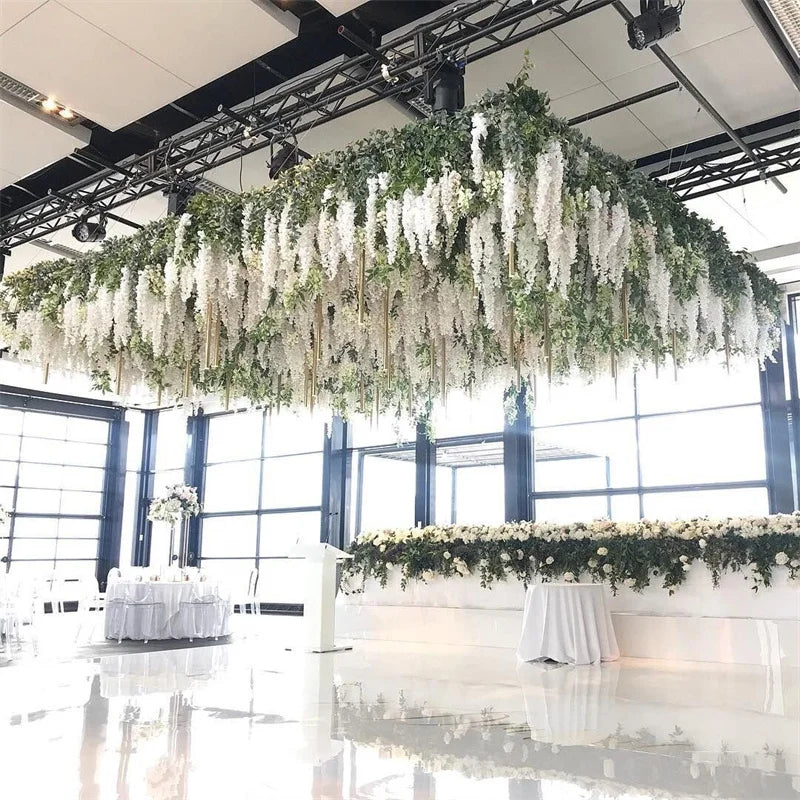 An artificial wisteria flower garland hangs from the ceiling in a large, cascading display.