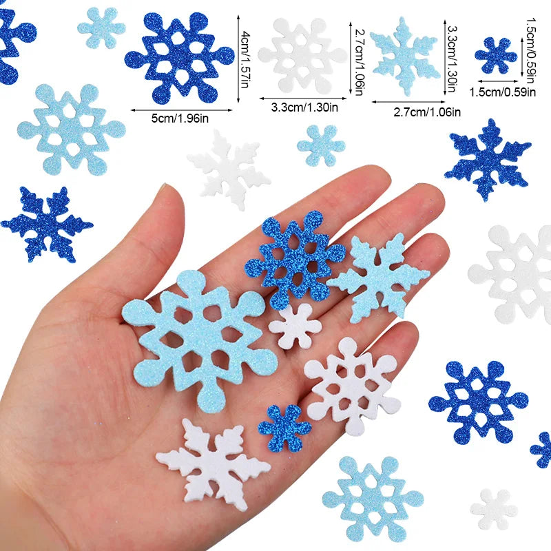 Une main montre divers autocollants de flocons de neige en mousse auto-adhésifs bleus et blancs pour la création et la décora