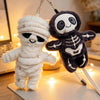 A plush keychain featuring a mummy skeleton design in white and dark gray.