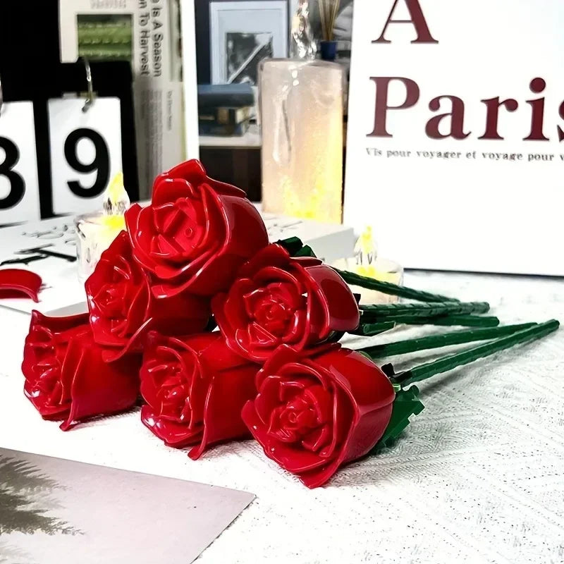 A bouquet of red silk rose building blocks displayed on a white surface.