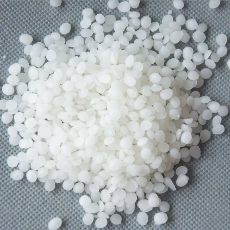 A pile of white microcrystalline wax pastilles for cosmetics.