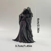 A dark, flowing hooded figure resembling a grim reaper collectible figurine.