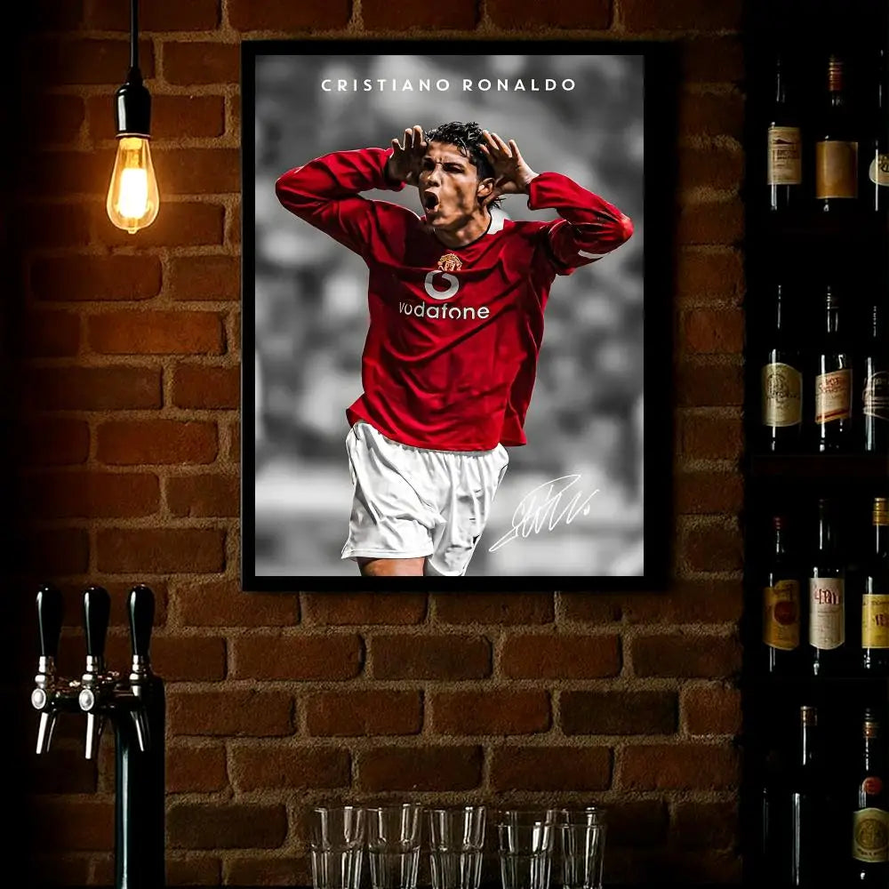 A framed poster of Cristiano Ronaldo celebrating, featuring a red shirt and white shorts against a dark background.