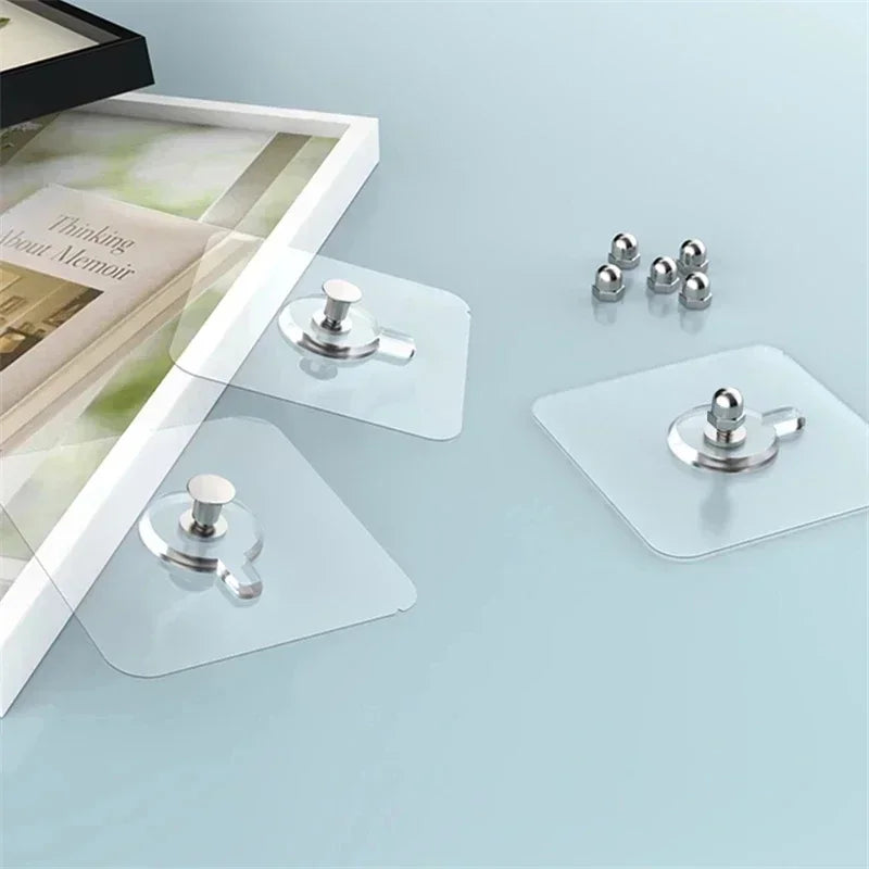 Clear adhesive wall hooks with silver mounting plates and hooks displayed on a light blue surface.