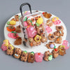 A collection of small capybara figures in various colors and textures arranged on a white circular tray.