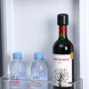 A glass shelf displays two clear plastic water bottles and a dark wine bottle labeled Amigos Mios