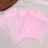 A stack of sheer pink organza drawstring bags for jewelry, candy, and party favors.