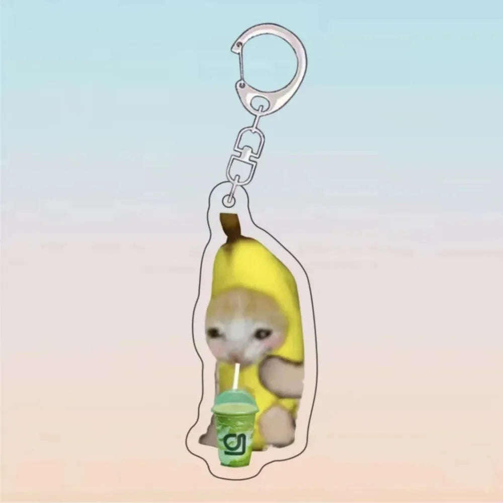 A yellow cat holding a green drink, attached to an acrylic keychain.