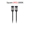 Two black square solar pathway lights with illuminated bulbs.