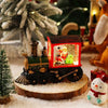 A miniature Christmas train with LED lights and a water-filled crystal ball displayed on a wooden surface.