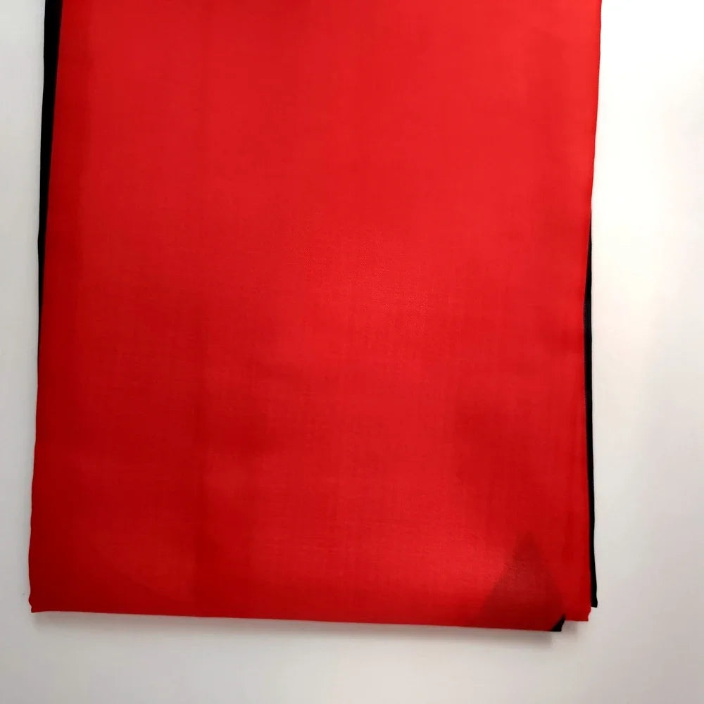 Un vibrante tapiz rojo con el diseño de la bandera ucraniana, mostrado contra una pared blanca.
