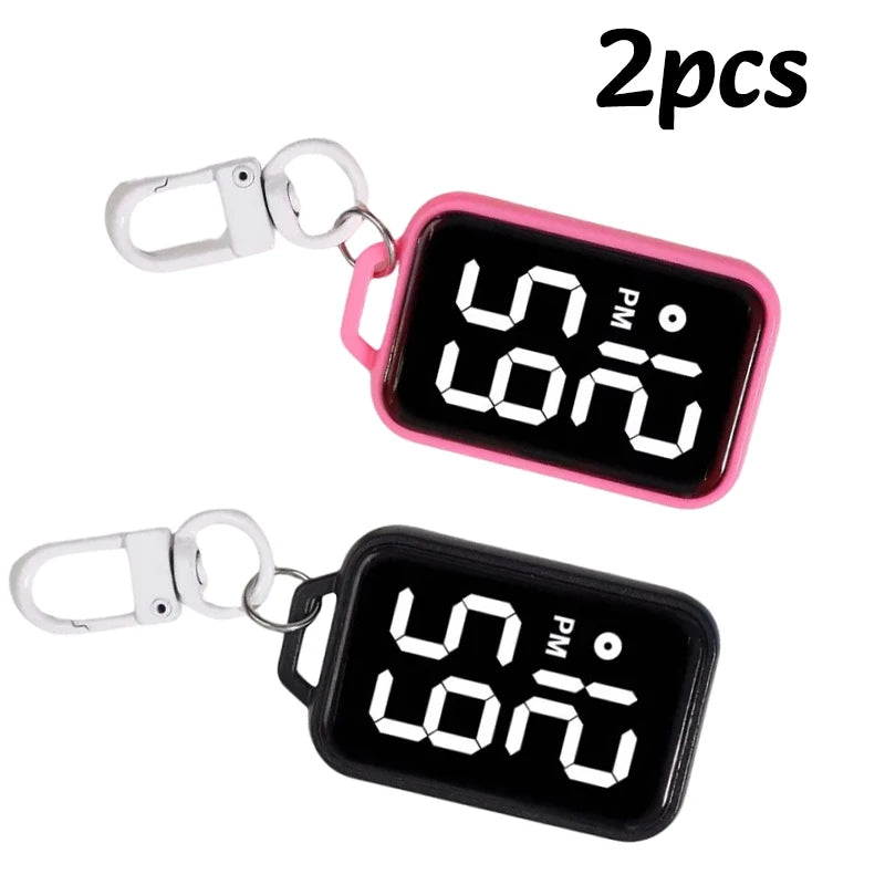 Two black LED keychain pocket watches with digital displays and silver clasps