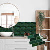 A kitchen backsplash featuring dark green rectangular vinyl tiles installed above a white countertop and sink.