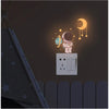 A set of luminous wall stickers featuring an astronaut, stars, and a crescent moon on a dark gray background.