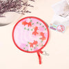 Pink fabric fan with orange silhouette designs for portable cooling