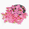 A cluster of pink silk artificial flower heads on a dark background.
