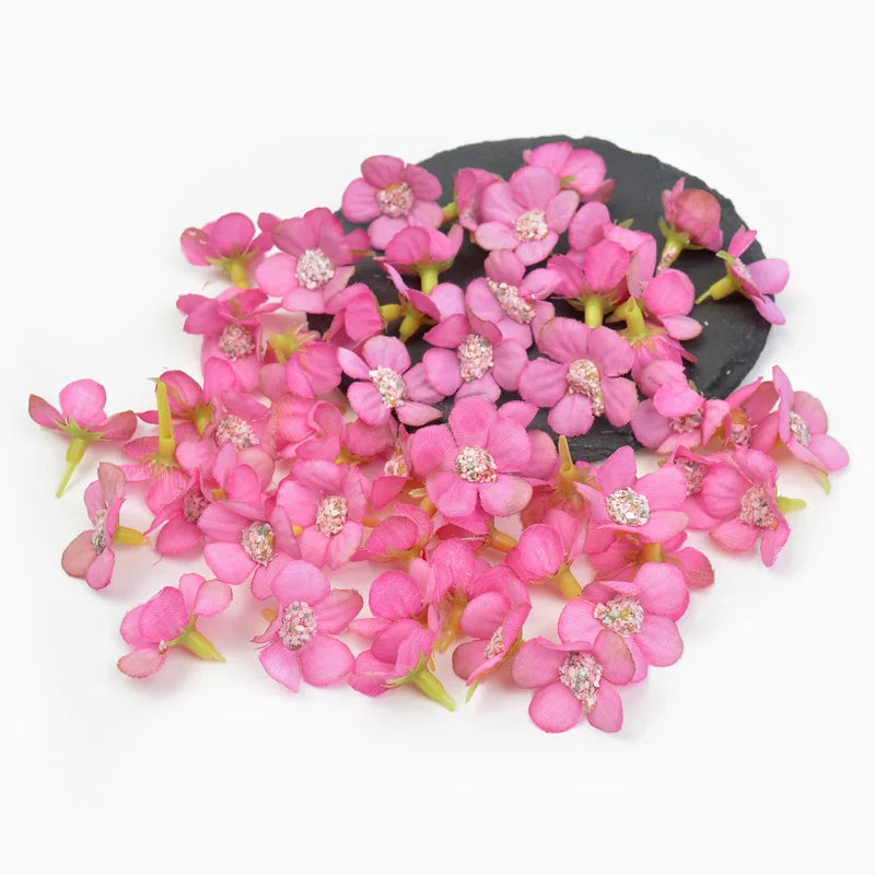 A cluster of pink silk artificial flower heads on a dark background.