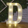 A glowing white alphabet letter D made of LED lights resting on a wooden surface.