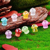 Collection de figurines de champignons phosphorescents de différentes couleurs posées sur de la mousse verte et du bois.