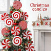 Christmas candies featuring red and white swirl patterns decorating a festive evergreen tree.