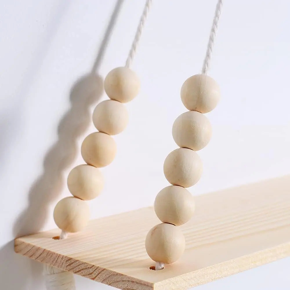 Handmade macrame wood wall shelf with tassel featuring a string of round wooden beads.