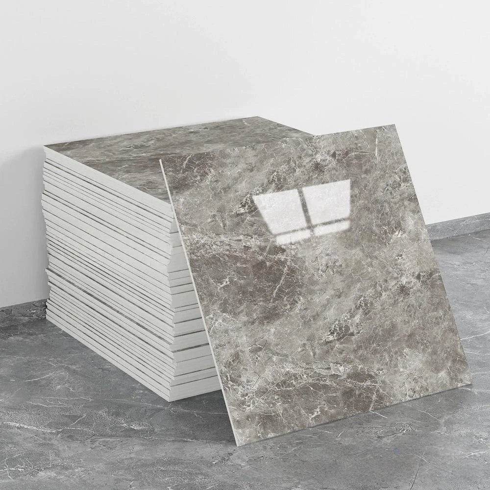 A stack of self-adhesive marble tile stickers is shown next to a single rectangular tile sample on a gray floor.
