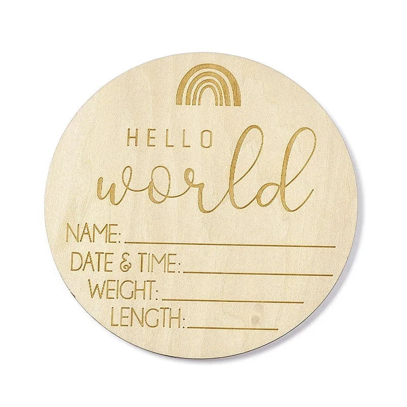A round natural wood baby milestone disc with a rainbow design and lines for name, date & time, weight, and length.