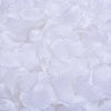 White artificial silk rose petals scattered on a surface.
