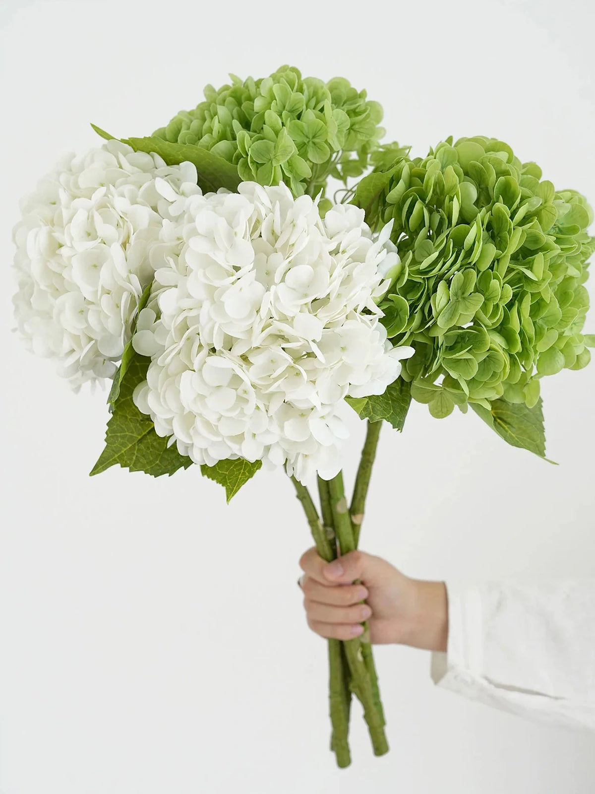 A bouquet of white and green hydrangea silk flower branches for weddings and home décor.