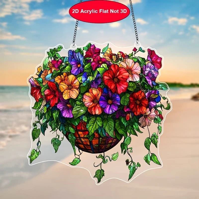 A colorful acrylic floral pendant featuring various flowers and leaves suspended by a chain against a beach sunset background