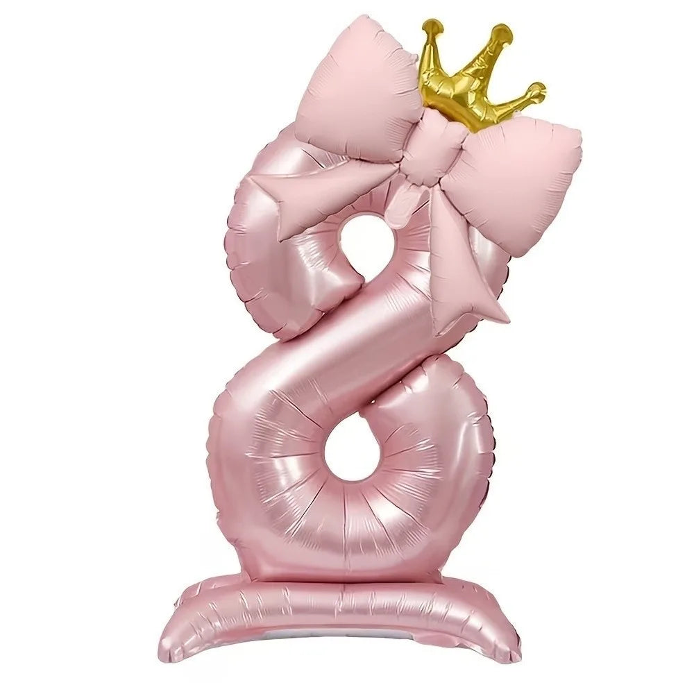 A pink foil balloon shaped like the number 8 with a gold crown topper