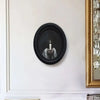 Black framed wooden wall art featuring a candlelit hand holding a flame