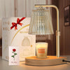 A gold-toned adjustable electric candle warmer lamp with a textured glass shade and a candle on a wooden base.