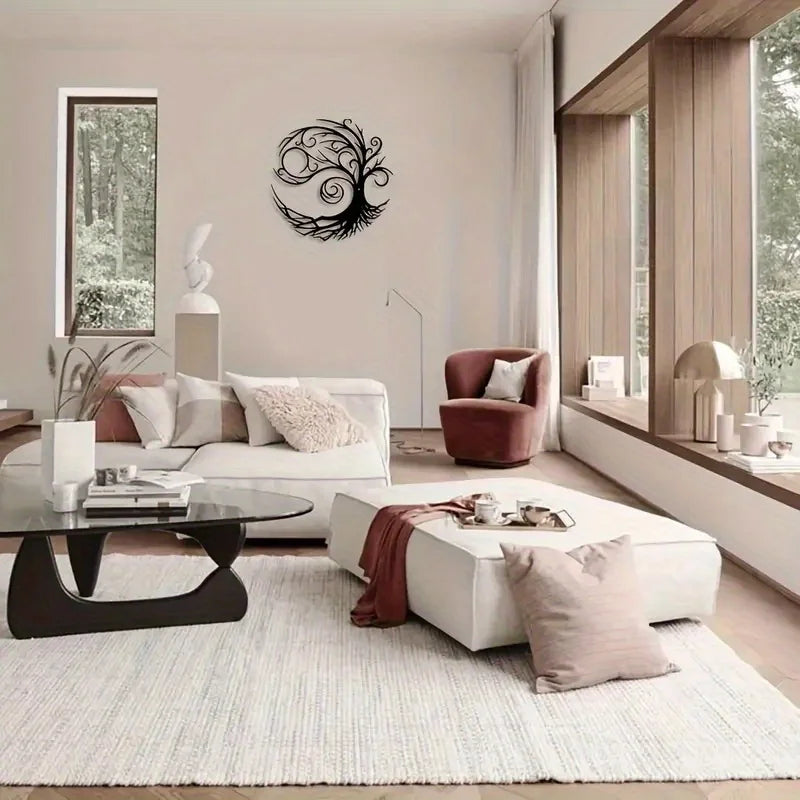 A modern living room featuring a white sofa, accent pillows, and a dark wood coffee table with a black tree of life metal wal