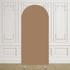 Un arco de tela beige liso y alto con arabescos blancos decorativos sobre un suelo de madera clara.