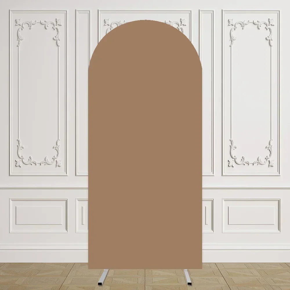 Un arco de tela beige liso y alto con arabescos blancos decorativos sobre un suelo de madera clara.