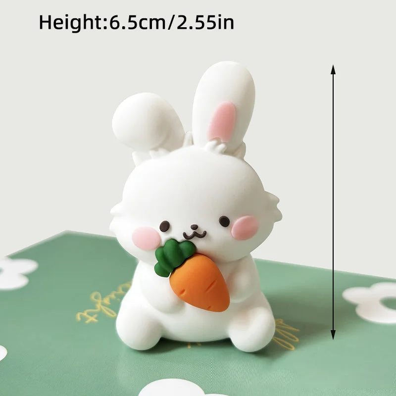 A white rabbit shaped cake topper with an orange carrot detail sitting on a green surface.