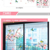 Pink cherry blossom and blue butterfly wall stickers displayed on a glass door panel.