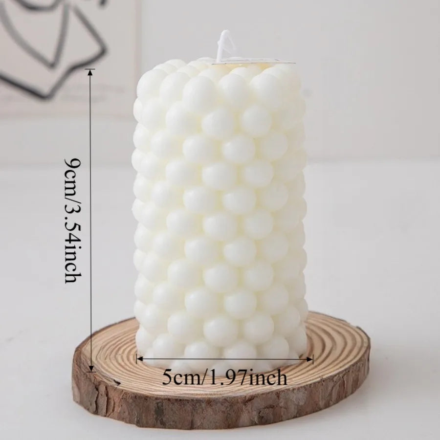 A white Nordic bubble scented soy candle is displayed on a wooden coaster.